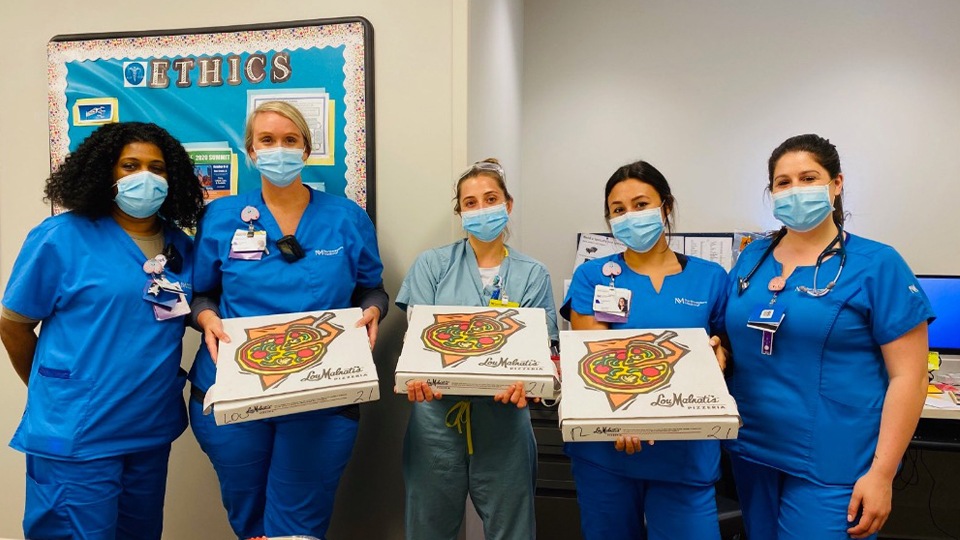 The dental team holding pizzas
