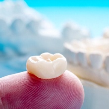 Closeup of dental crown in Evanston on finger