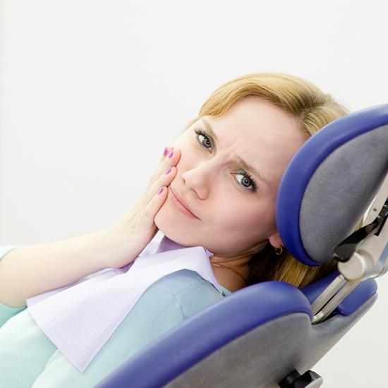 Female patient with tooth pain visiting emergency dentist in Evanston, IL