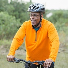 Man smiling and riding his bike