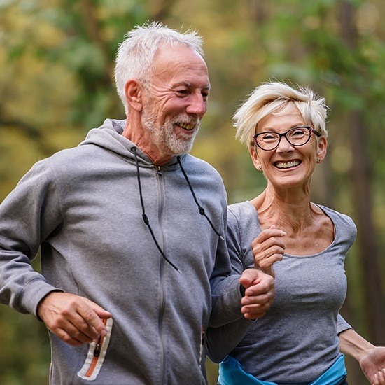 Older man and woman smiling after visiting the holistic dentist