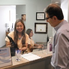 Man discussing cost of dental implants with dental office team member